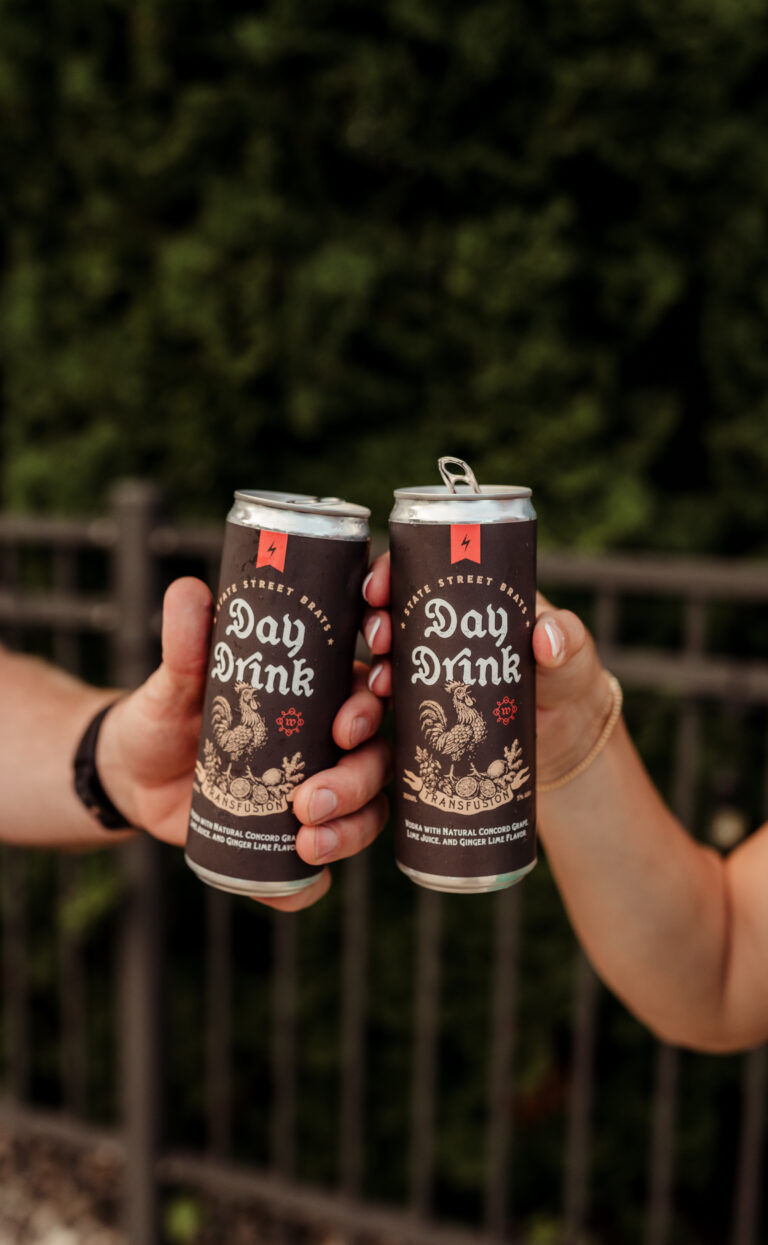 Three friends touching cans of Day Drink together in a toast.