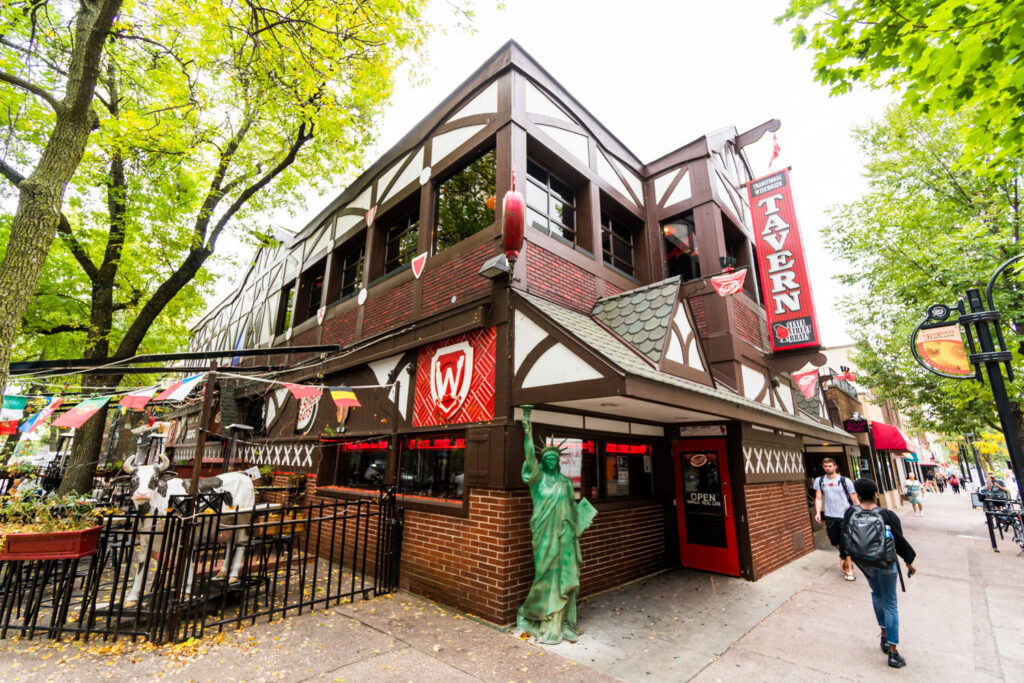 The State Street Brats tavern today at 603 State Street — its Tudor facade and neon TAVERN sign, with the Lady Liberty statue out front.